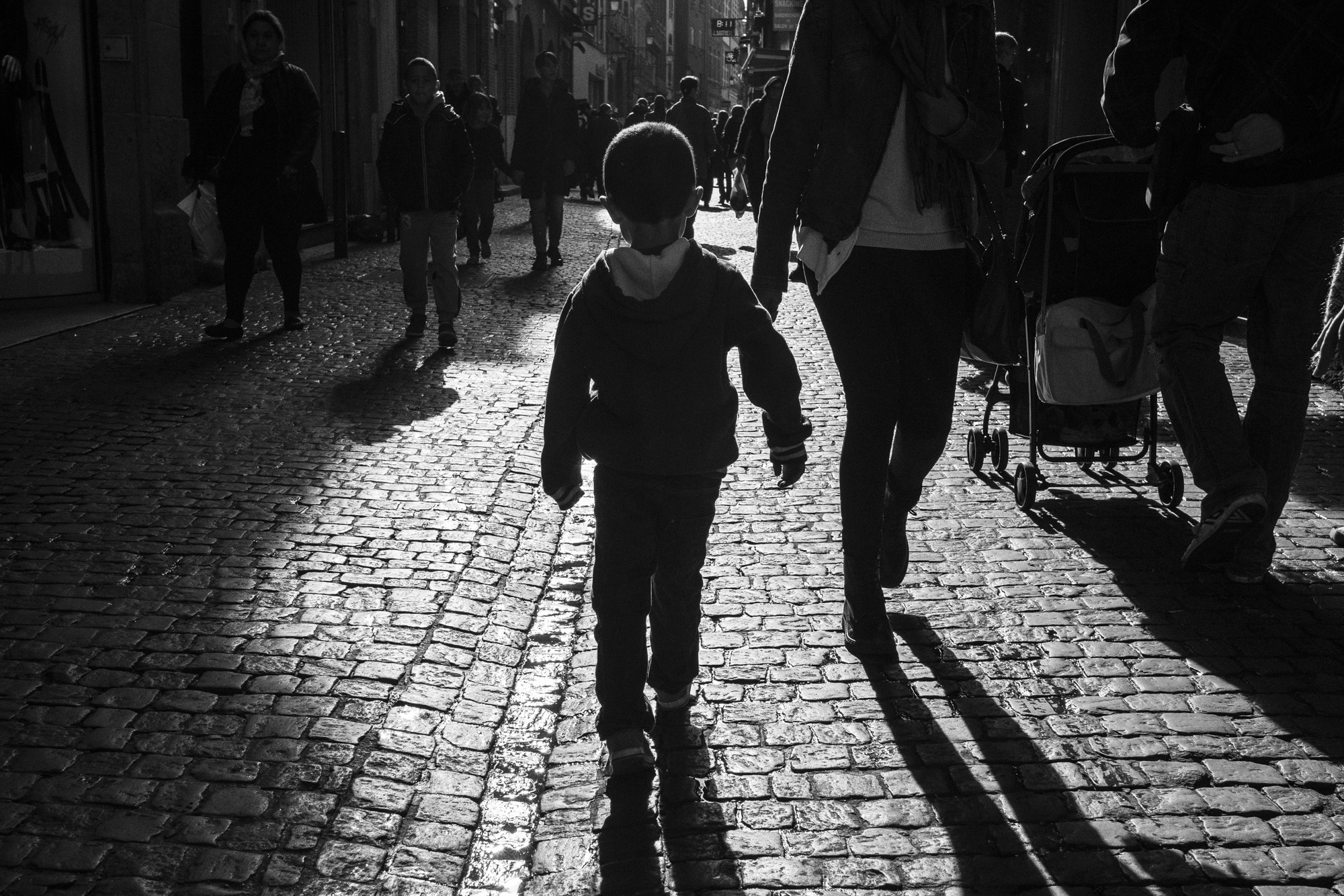 Un enfant à contre-jour dans une rue pavée, photo de Nicolas Croce
